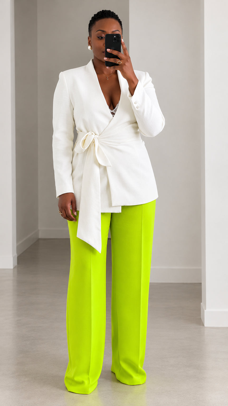 Front view of model wearing white wrap blazer with tie belt and neon lime green wide leg trousers