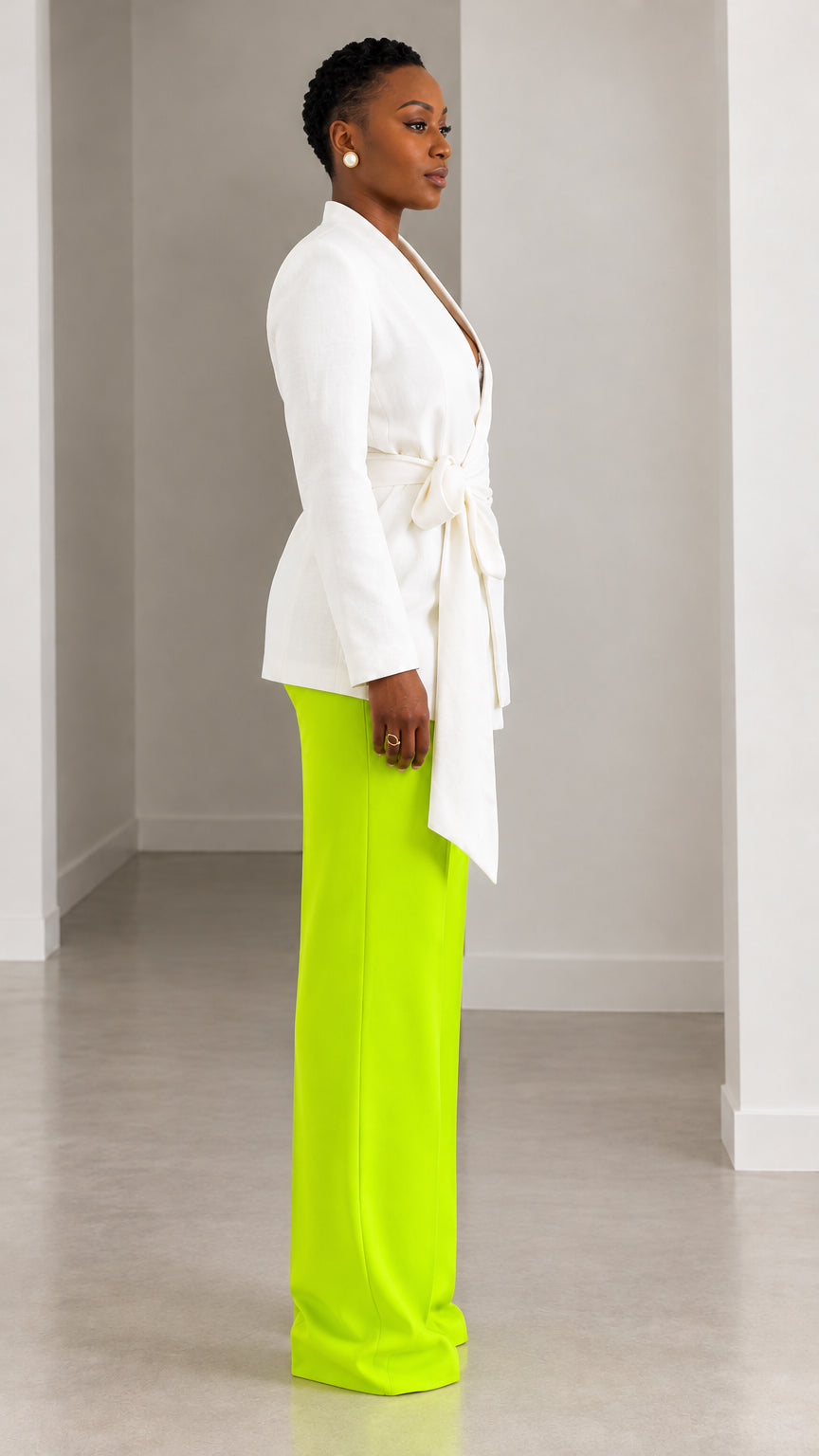 Side profile view of model wearing white wrap blazer and neon lime green wide leg pants