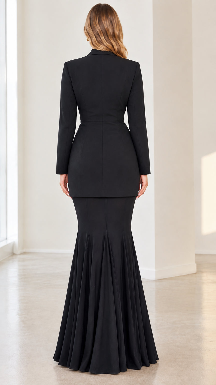 Back view of black longline blazer and pleated flared mermaid maxi skirt