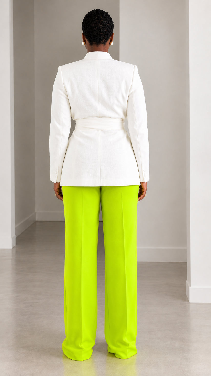 Back view of model wearing white tie-waist blazer and neon lime green trousers
