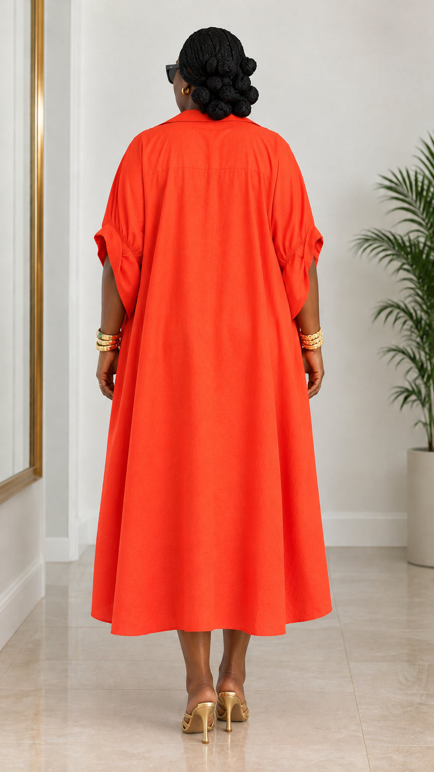 Back view of woman showing full loose silhouette of orange kaftan dress