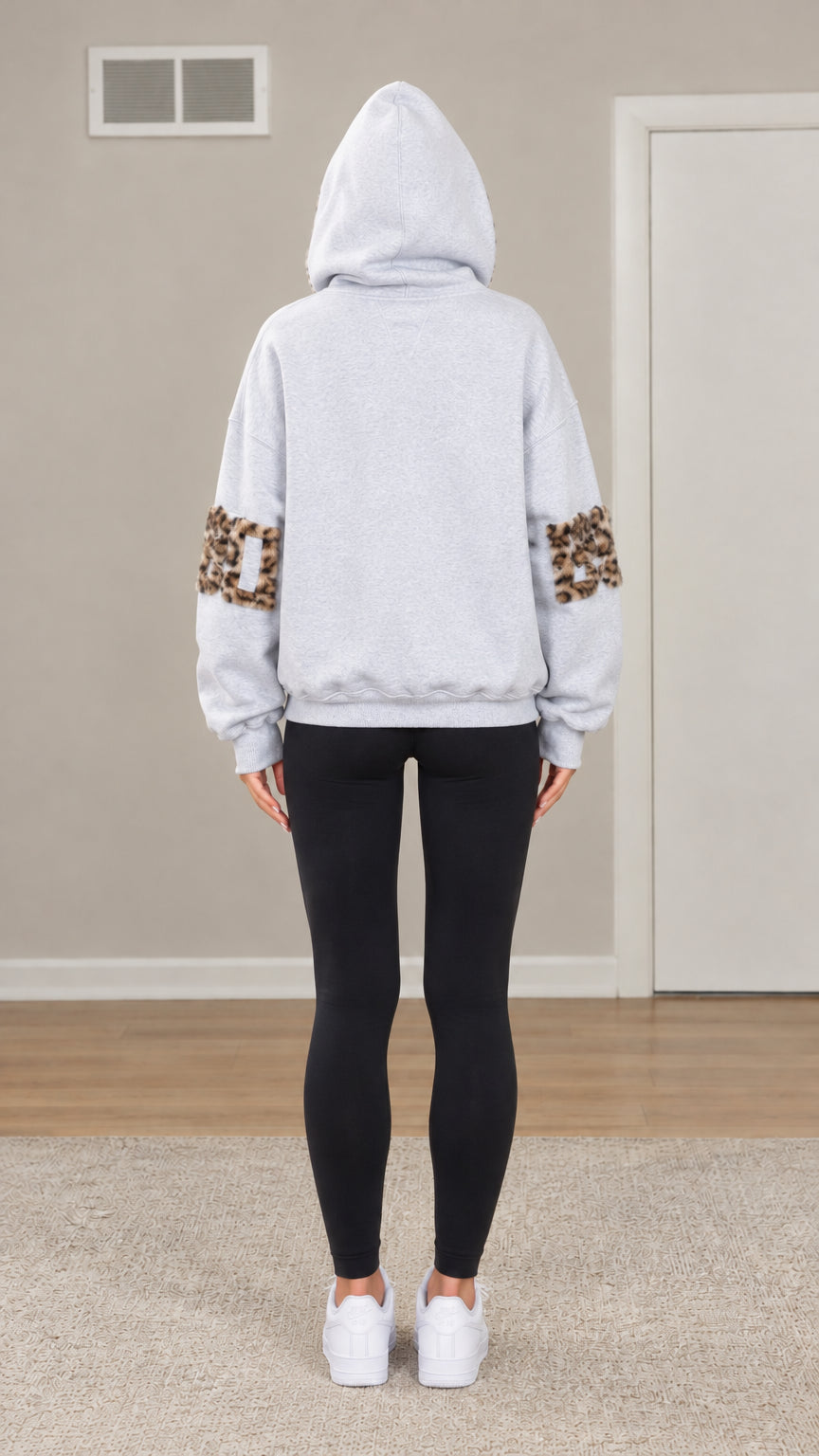 Back view of woman wearing Light Grey oversized hoodie with leopard sleeve patches