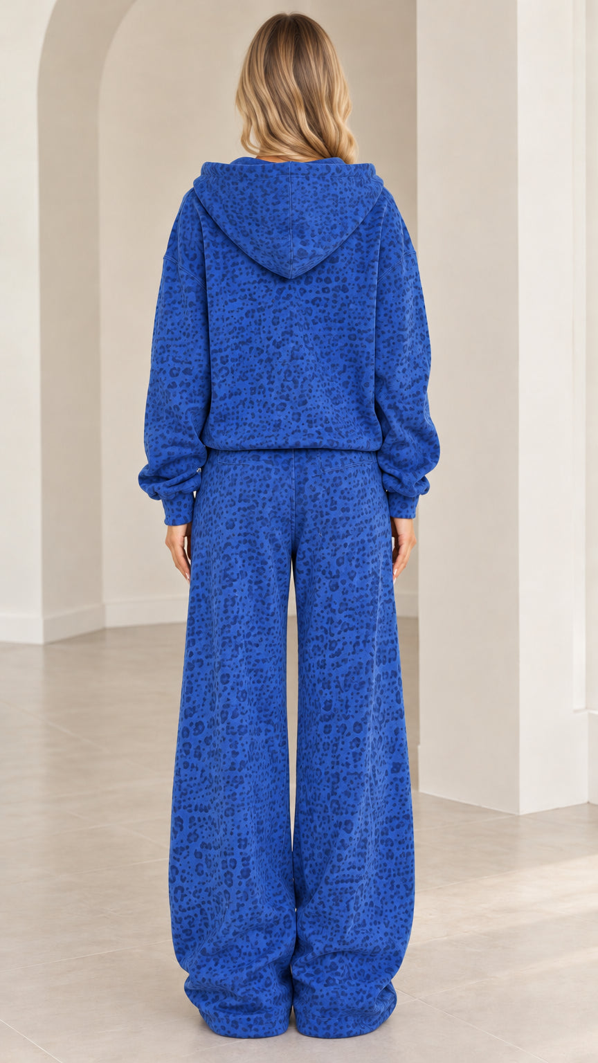 Back full-length view of woman wearing Royal Blue hooded top and wide leg pants set