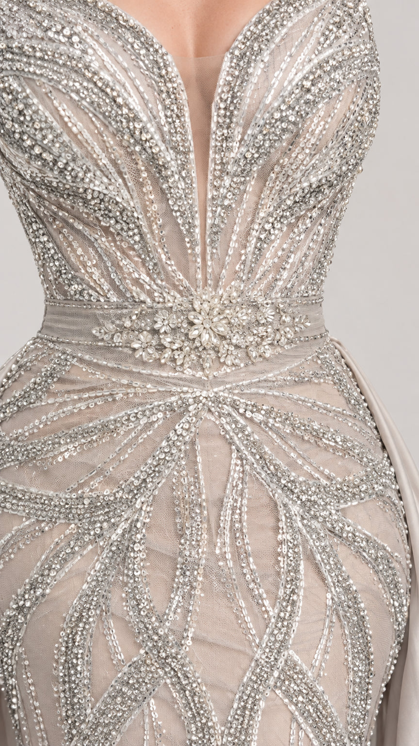 Close-up detail of shimmering silver scroll sequin beading and mesh plunge sweetheart neckline