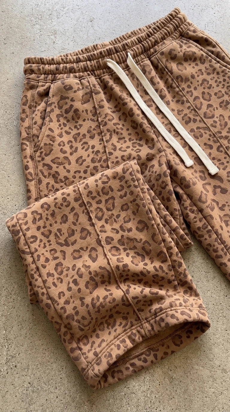 Flat lay close-up of camel leopard print sweatpants showing drawstring waistband and fabric texture
