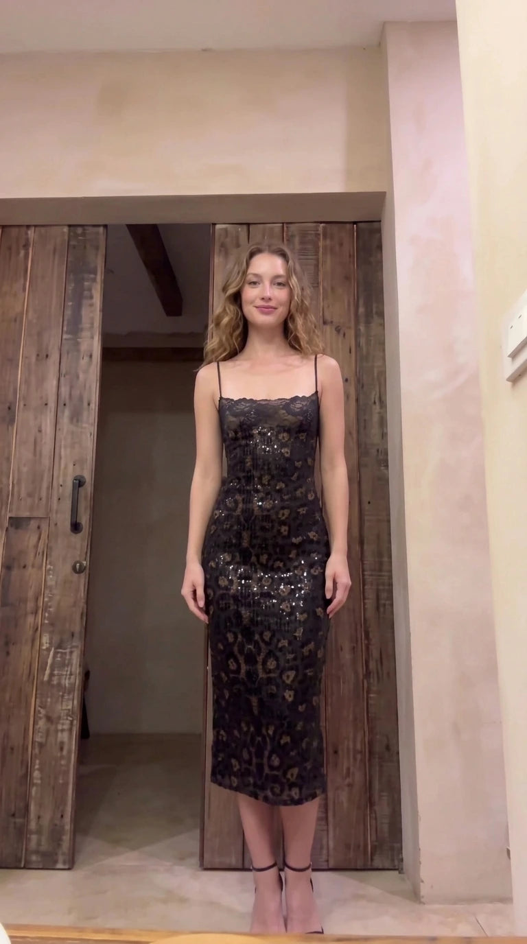 Model wearing black sequin leopard print slip midi dress with lace trim