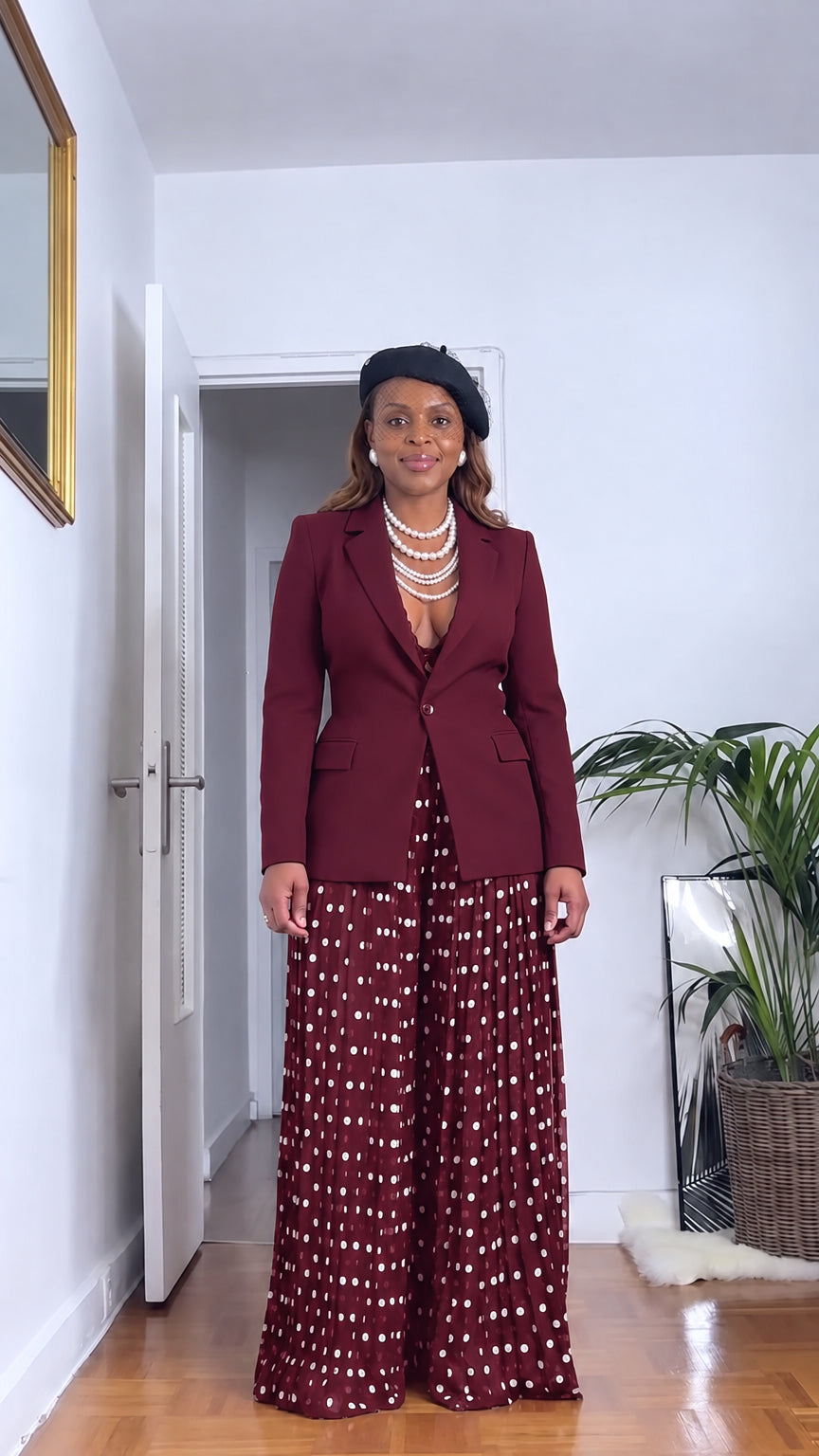 Front full view of woman wearing burgundy wine red tailored blazer and burgundy polka dot pleated wide leg pants